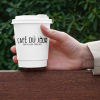 Šálek Café du Jour v ruce, připravený na ochutnání